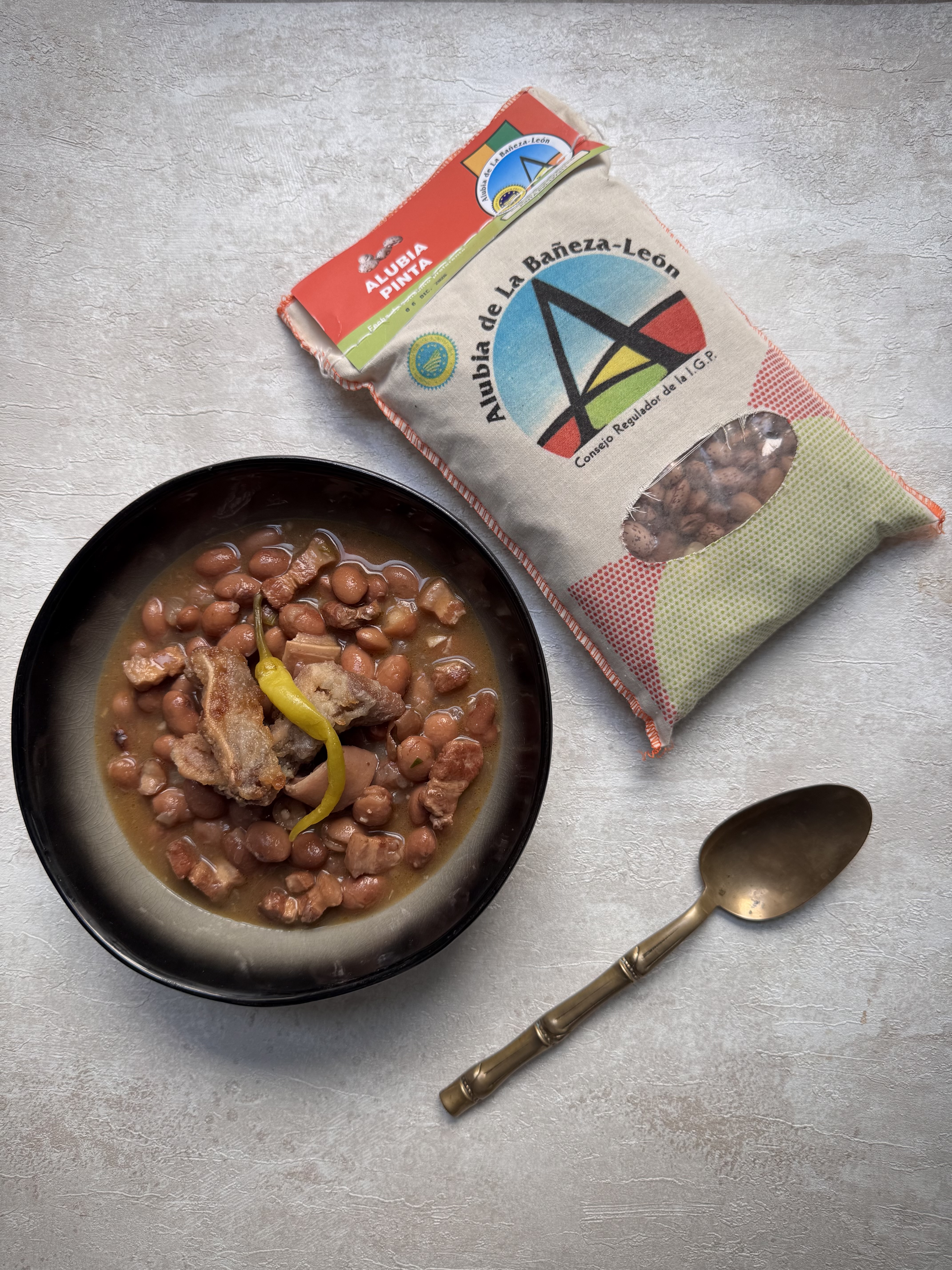 Guiso de alubias pintas con panceta y oreja de cerdo.